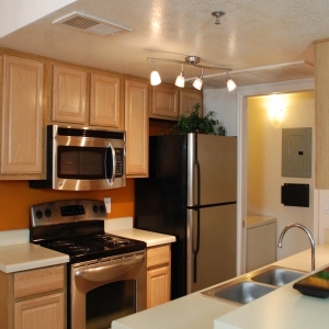 model home kitchen with stainless appliances and track lighting